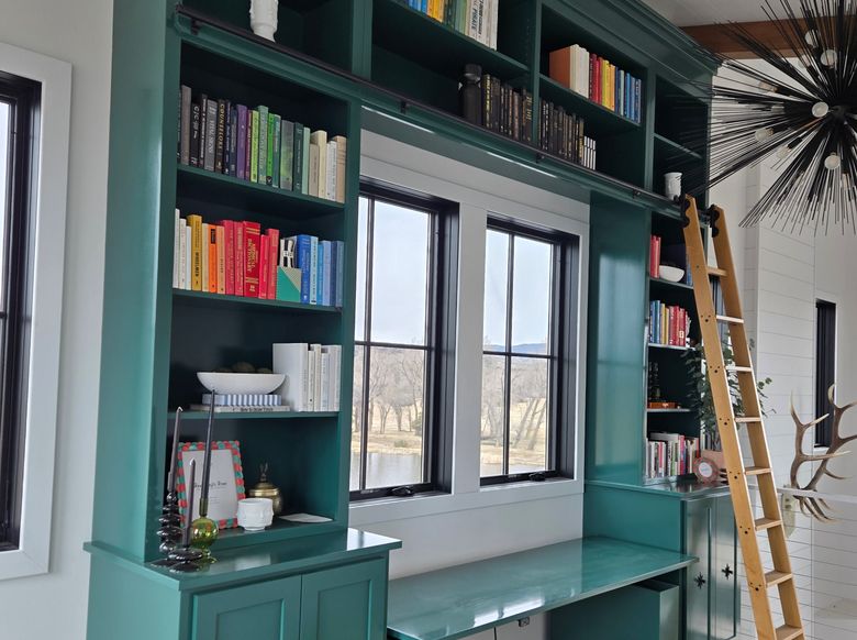 custom bookshelf with ladder and window seat