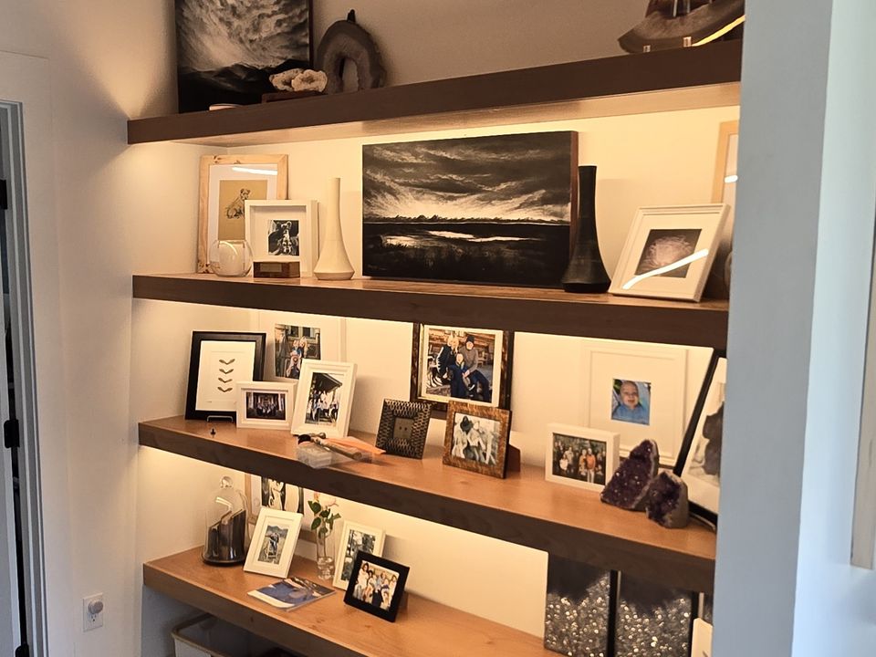 custom built-in bookshelves with framed art and warm interior lighting