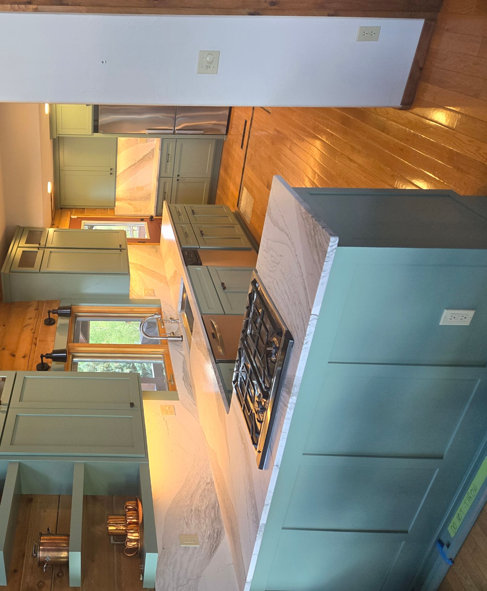 smooth finished green kitchen cabinets in a cozy mountain kitchen